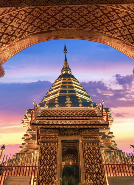 Wat Phra That Doi Suthep, Chiang Mai, Thailand, a golden temple illuminated at dusk, with a beautiful sky in the background.